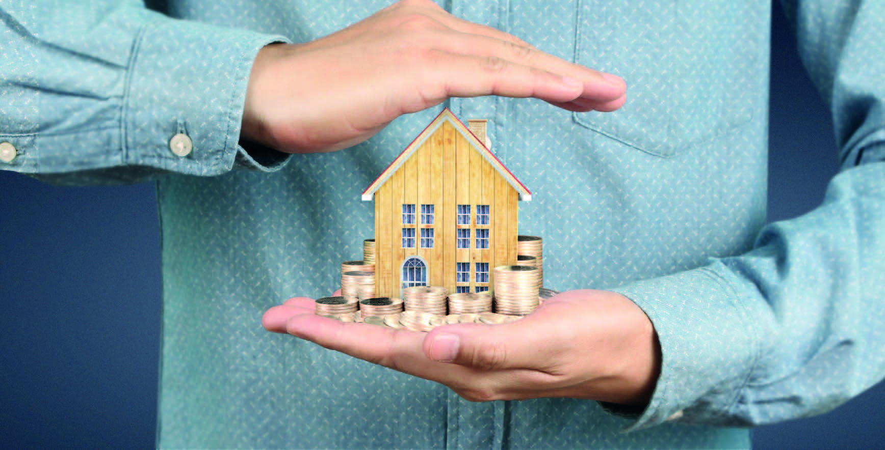 Image of a person holding a small house and coins